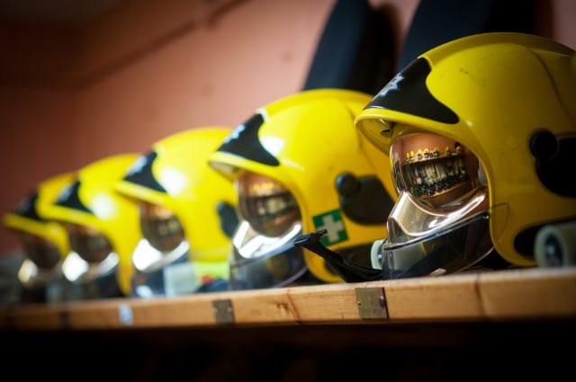 A row of helmets on a shelf